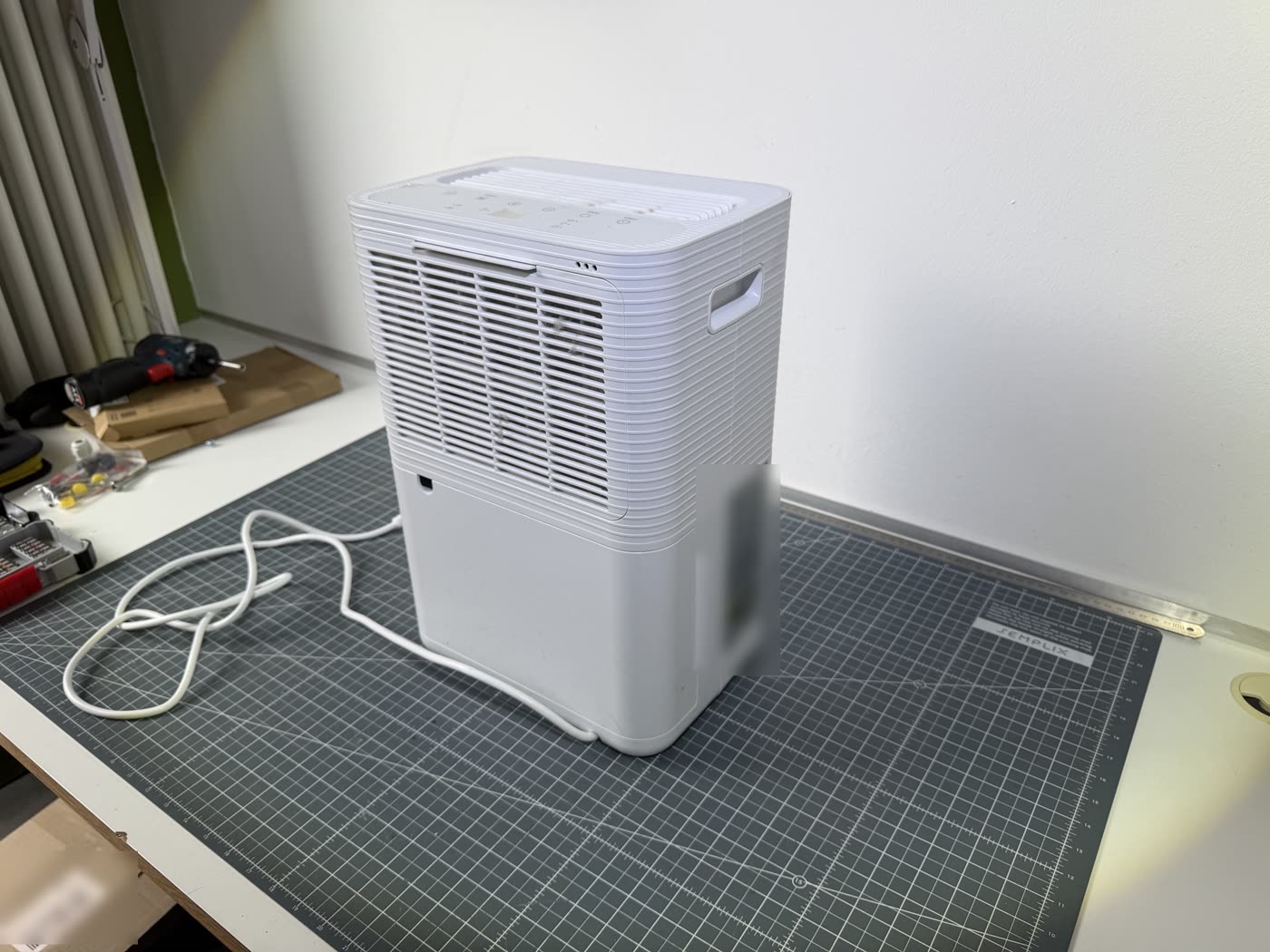An identical, undamaged appliance on a workbench, obtained for examination of the materials.